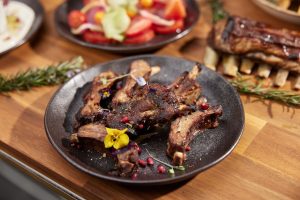 Spit roast Greek lamb shoulders bone over coal